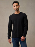 A man wearing a black long-sleeve flannel shirt and blue jeans. The thermal that keeps up with the whole weekend.