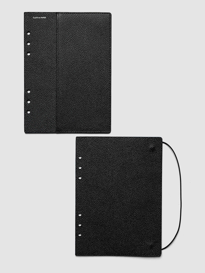 Both covers of the A5 6-Ring Punch Genuine Leather Planner Cover Set laid flat side by side, the front cover with its sewn pocket seam and the back cover with the bungee cord looping out from the edge