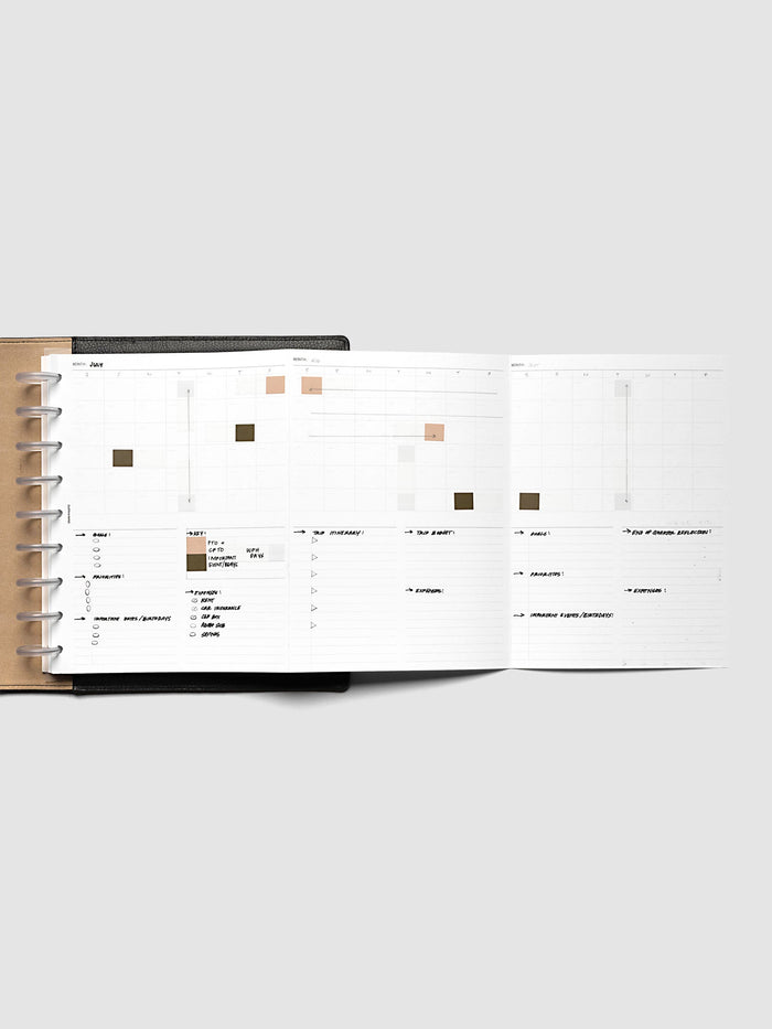 Monthly Fold Out Planner Insert Set of 2, HP Classic 9-Disc Punch, the insert unfolded inside a black discbound planner with three months written out across the panels, peach and olive blocks marking dates and handwritten notes filling the lower sections