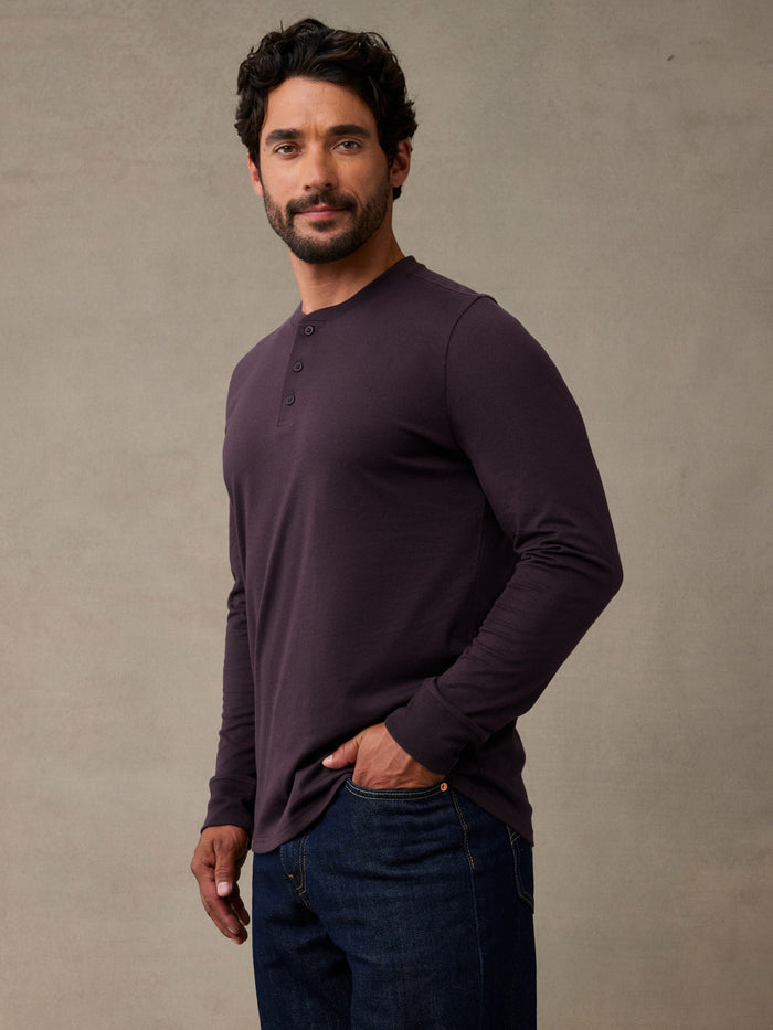 Man wearing deep mulberry colored henley long sleeve shirt