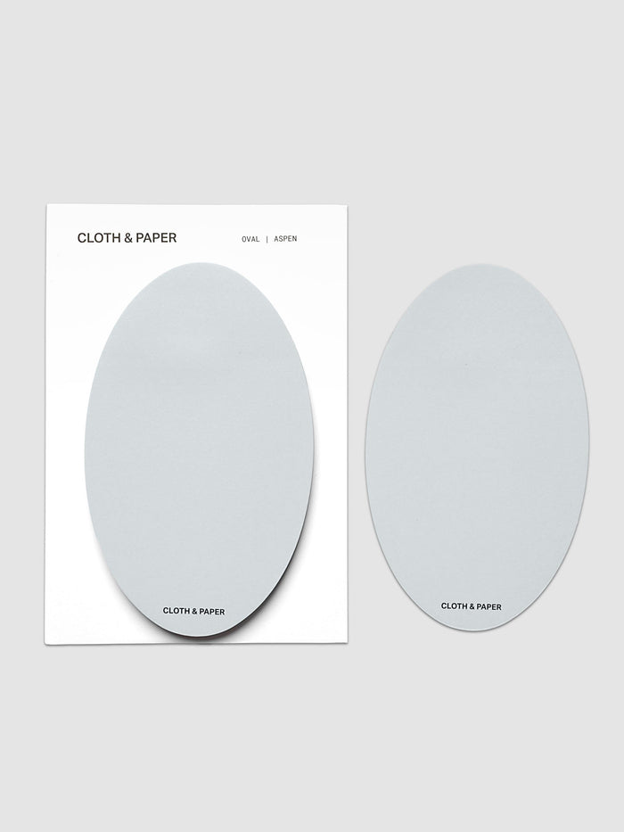 Oval Sticky Notes | Aspen with the pad on its white backing card beside a single loose oval sheet, both in the same soft pale blue gray, on a light gray background