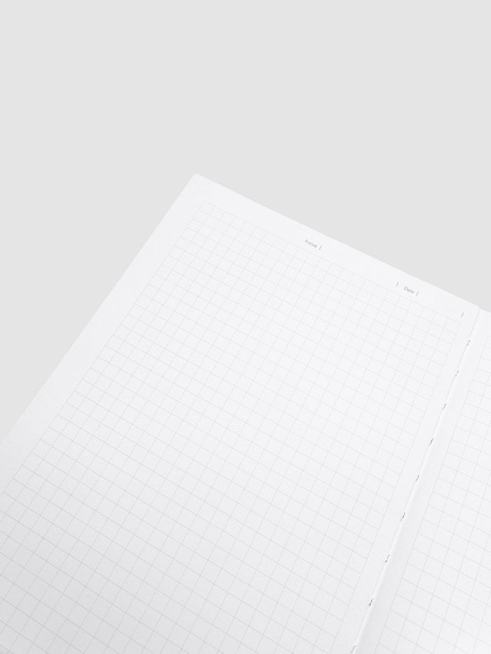 Close-up of a single graph paper page in the Precision Notebook | A5, showing the Focus and Date line and the stitching along the gutter