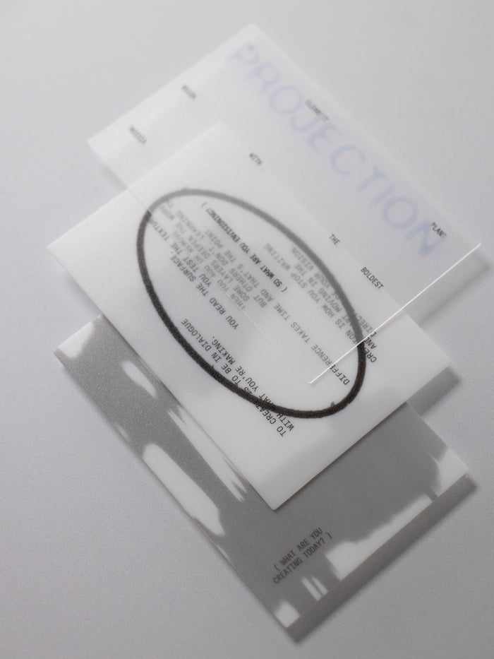 A journaling card set featuring a black ink oval and text, layered over a white card with the word 'PROJECTION' in blue, on a light gray background.