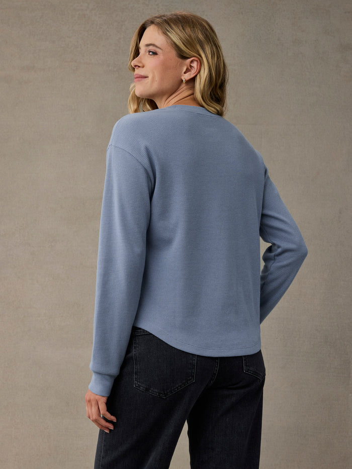 A woman shown from the back wearing a Skyline blue long-sleeve cozy thermal and dark jeans. Soft 280 GSM waffle knit fabric.