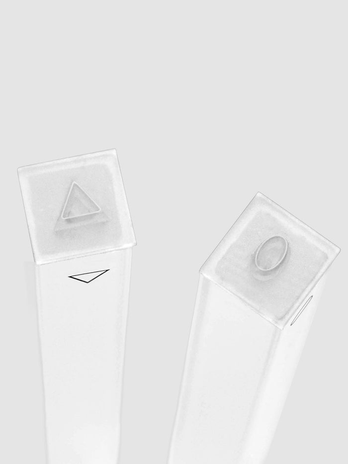 Detail of the Stamp Sticks | Set of 2 stamping faces, two clear square stamping heads standing upright, one carrying a raised triangle and the other a raised oval