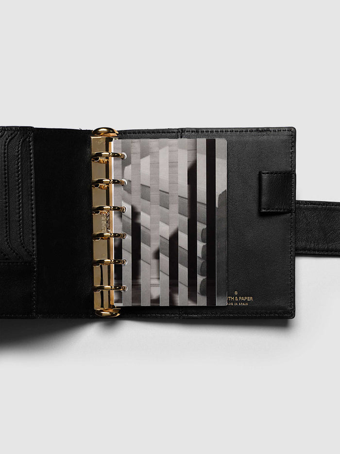 Both layers of the Pocket Strips Planner Dashboard Duo overlapping, the clear plastic top layer of silhouettes in motion set across the vellum base layer of stacked books